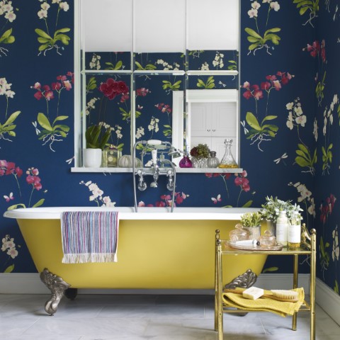 yellow bath with decorative wallpaper and a window on the wall behind