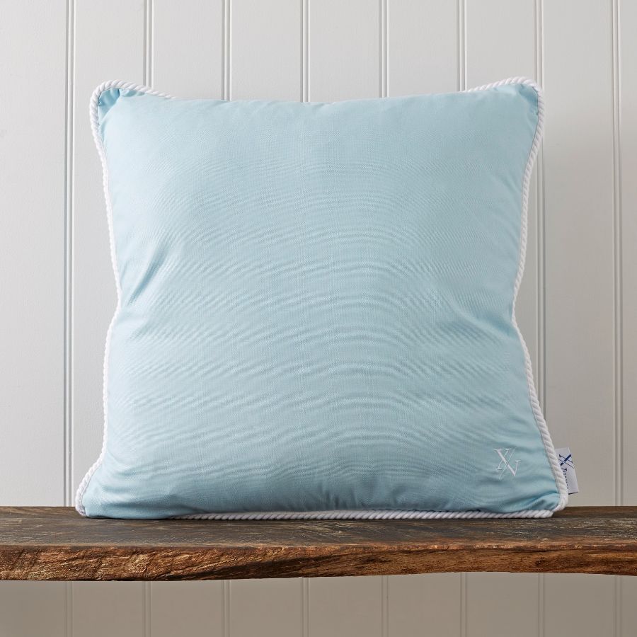 A blue pillow on a wooden surface Description automatically generated