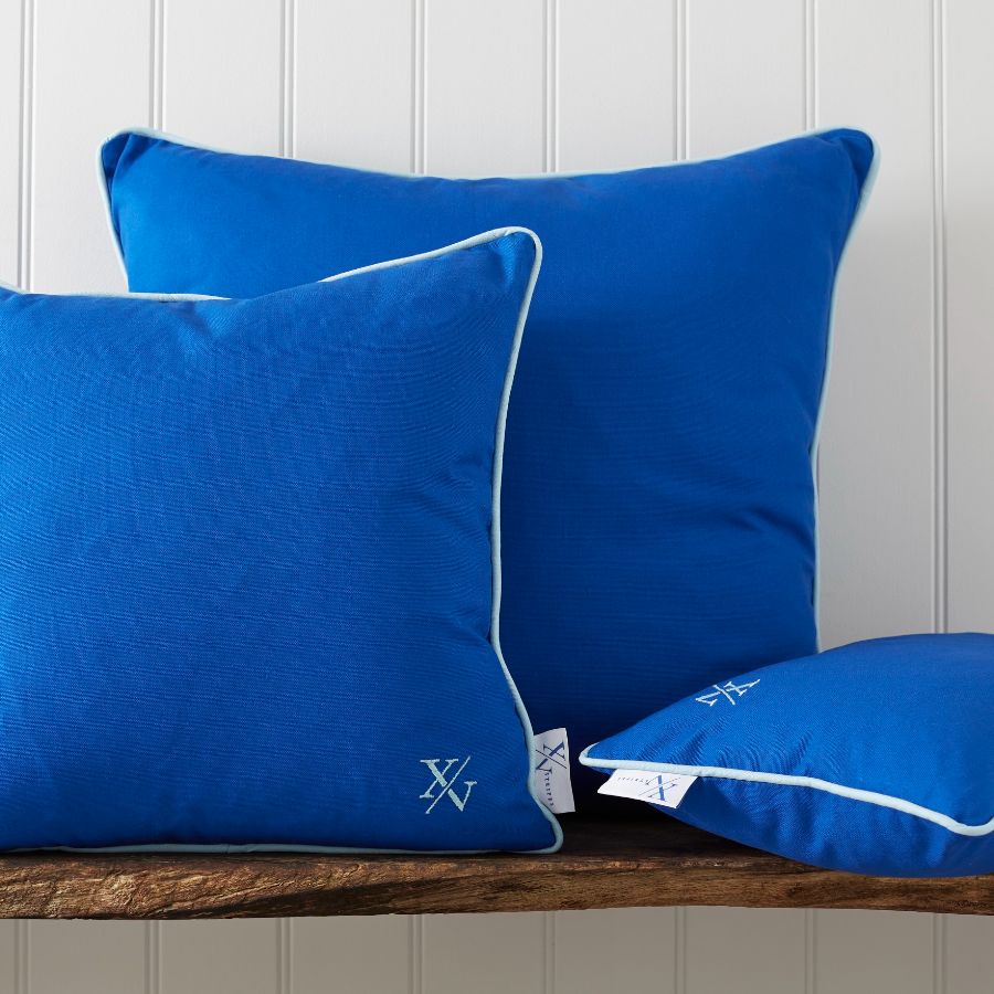 A group of blue pillows on a bench Description automatically generated