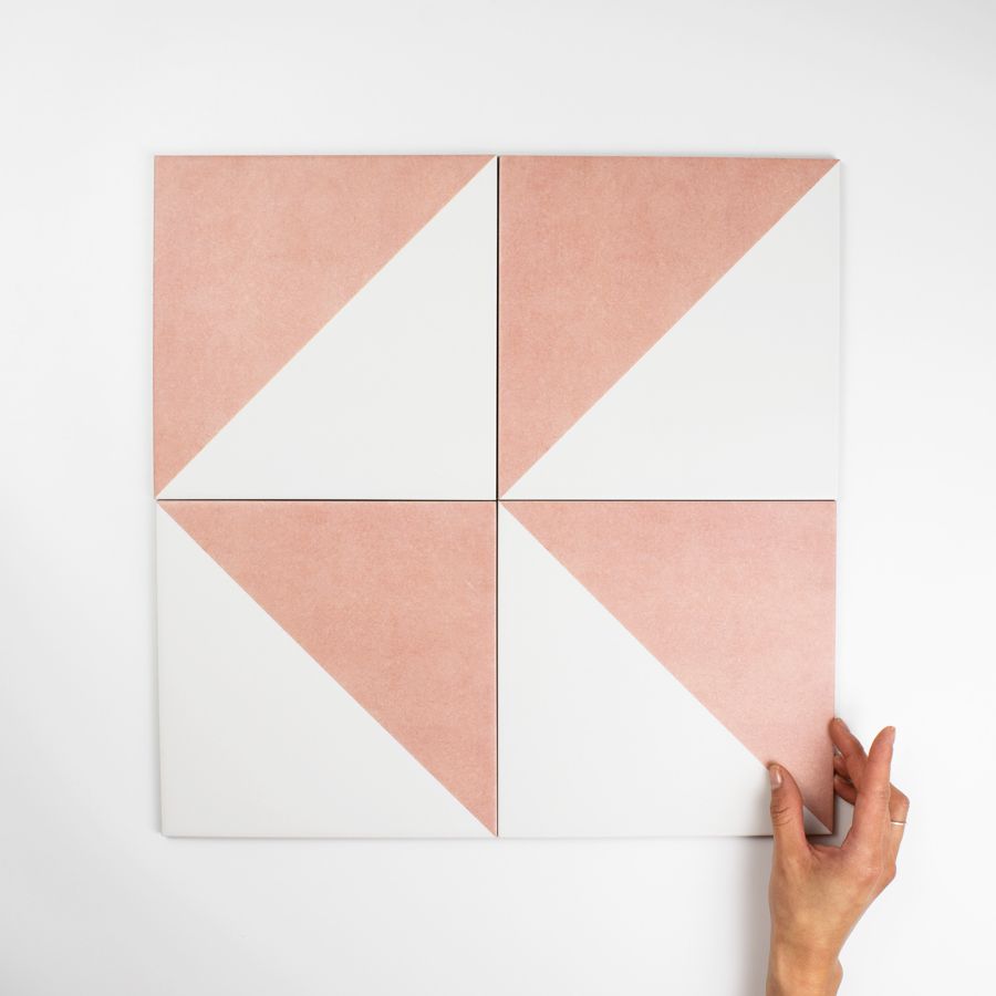 A hand holding a white and pink square Description automatically generated