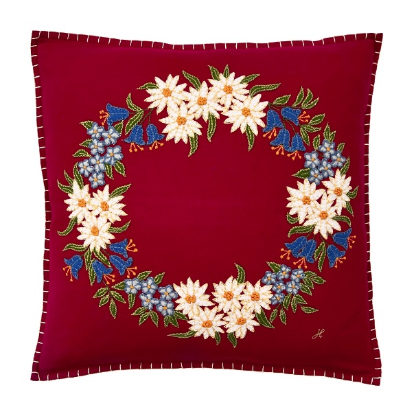 A red pillow with a floral design

Description automatically generated