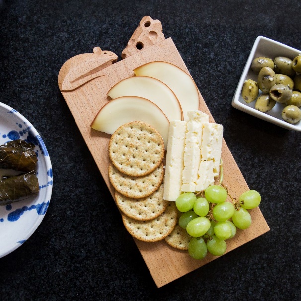 A wooden board with cheese grapes and crackers

Description automatically generated